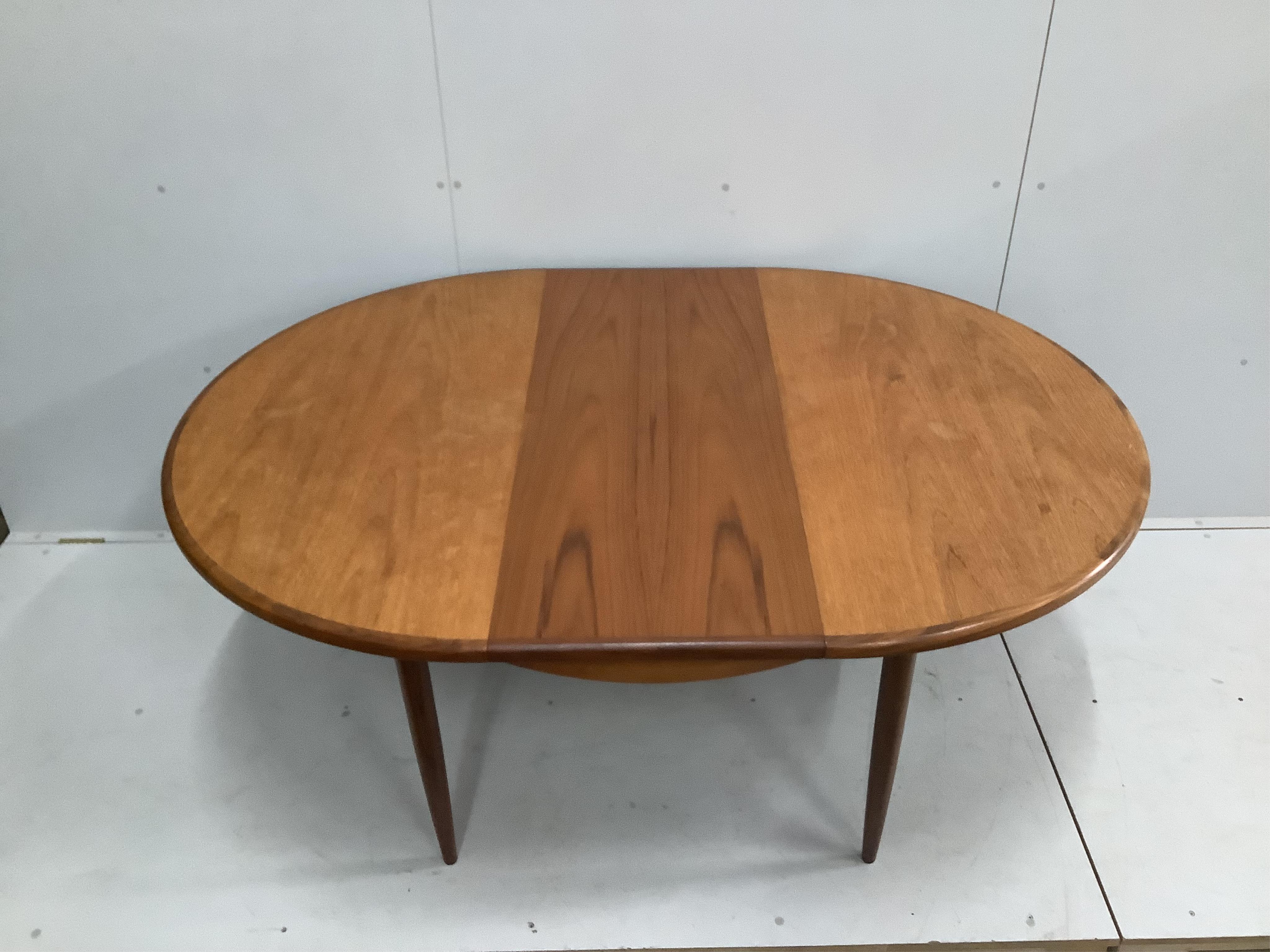 A mid century G Plan teak extending dining table, width 168cm extended, depth 122cm, height 73cm, together with six teak dining chairs. Condition - good